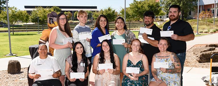 Butte College students hold scholarship checks.